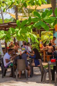 un gruppo di persone seduti ai tavoli in un ristorante di Palmarito Beach Hotel a Tierra Bomba