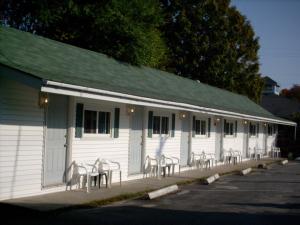 a building with tables and chairs in front of it at Mackenzie Motel & Cottages in Shelburne