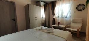 a bedroom with a bed and a chair and a window at Ellora Suite in Salamina