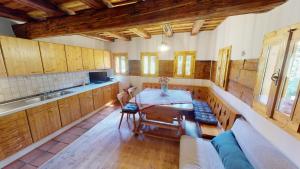 a kitchen with wooden cabinets and a table and a couch at Ferienhaus Kleissner in Nestelberg