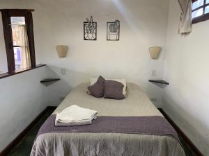 a bedroom with a bed with two pillows on it at Altos de la Laguna in Chascomús