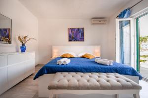 a bedroom with a blue bed with two towels at Apartman Zorka in Povlja