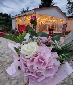 un mazzo di fiori rosa davanti a un tendone di Apartmány Nad Kostolom a Betliar