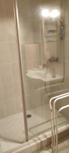 prysznic ze szklanymi drzwiami i umywalką w obiekcie La maison Do w mieście Lunas
