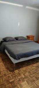 łóżko w sypialni z białą ścianą w obiekcie La maison Do w mieście Lunas