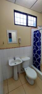 a bathroom with a toilet and a sink at Villa de María in Guayaquil