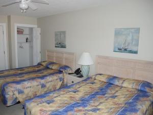 ein Hotelzimmer mit 2 Betten und einer Lampe in der Unterkunft Brunswick Plantation Studio Home 407L with Onsite Golf Course and Pools studio in Calabash