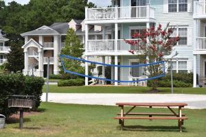 a picnic table and a blue rope swing in a park at Brunswick Plantation Studio Home 407L with Onsite Golf Course and Pools studio in Calabash