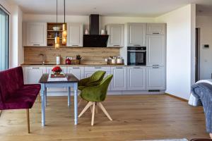 a kitchen with white cabinets and a table and chairs at Willhelm - Hauff in Engen