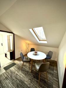 Zimmer mit einem Tisch, Stühlen und einem Dachfenster in der Unterkunft Pejzaž Zlatibora in Zlatibor + 7 Fotos