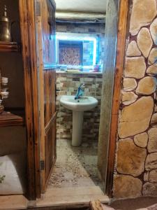 a bathroom with a sink and a stone wall at My Grandfather's House in Dana