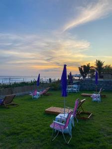 a group of lawn chairs and umbrellas on the grass at Casa do Point in Saquarema