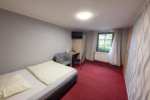 Schlafzimmer mit einem Bett, einem Schreibtisch und einem Fenster in der Unterkunft Hotel Am Rathaus in Menden