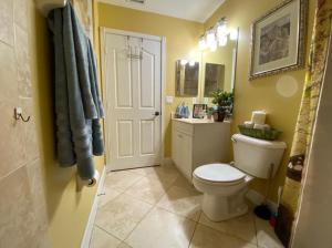 a bathroom with a white toilet and a sink at A Treasure Coast Gem. in Port Saint Lucie