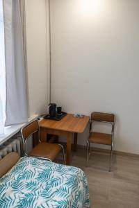 um quarto com uma mesa e cadeiras, uma mesa e uma cama em Mini Studio Vilnius Centre em Vilnius