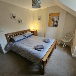 a bedroom with a large bed and a chair at Sleeps 8 Matlock/ Matlock Bath Pet Friendly in Matlock Bank