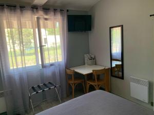 Schlafzimmer mit einem Bett, einem Tisch und einem Fenster in der Unterkunft Les Ouches in Fleurey-sur-Ouche
