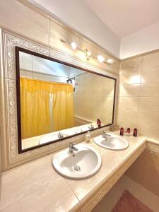 baño con 2 lavabos y espejo grande en Two-floor luxury big house in Karpathos, en Apérion