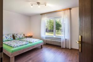 1 dormitorio con cama y ventana en Haus Isele, en Urberg