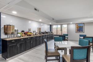 a restaurant with a table and chairs and a kitchen at Best Western Bloomington Edina - Minneapolis in Bloomington