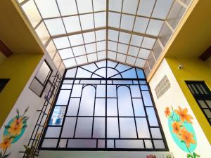une chambre avec une grande fenêtre dans un bâtiment dans l'établissement SAINT PETER'S LLAMA HOSTAL, à La Paz