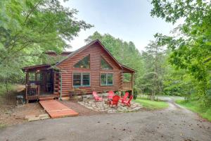 a log cabin with red chairs and a porch at Moonshine Manor Cabin with Fire Pit and Hot Tub! in Lake Lure