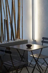 un tavolo e due sedie in una stanza di Glass House - Smart Rooms & Parking a Lecce