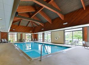 a large swimming pool in a building with wooden ceilings at Hampton Inn Chicago-Carol Stream in Carol Stream