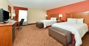 a hotel room with two beds and a flat screen tv at Hampton Inn Chicago-Carol Stream in Carol Stream