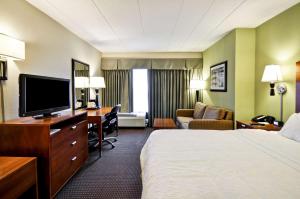 a hotel room with a bed and a desk with a television at Hampton Inn Chicago-Gurnee in Gurnee