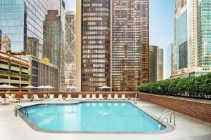 a large swimming pool in a city with tall buildings at Hilton Grand Vacations Club Chicago Magnificent Mile in Chicago