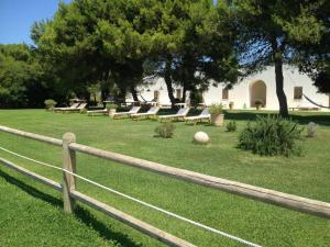 a group of benches in a field with trees at Masseria Autigne in Otranto