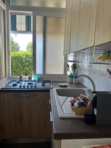 a kitchen with a sink and a stove and a window at L'angolo della felicità in Marina di Montenero