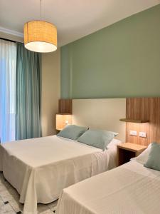 a bedroom with two beds and a large window at Albergo Degli Amici in Monterosso al Mare