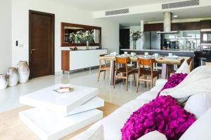 sala de estar con sofá blanco y mesa con flores púrpuras en Brand New and Amazing Penthouse! en Playa del Carmen