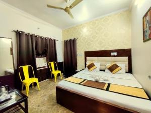 una camera con un letto e due sedie gialle di Goroomgo Krishna Residency Bareilly a Bareilly