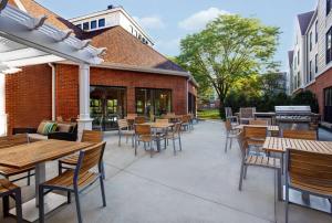 un patio con tavoli, sedie e griglia di Homewood Suites by Hilton Chicago-Lincolnshire a Lincolnshire