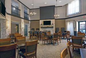 une salle à manger avec des tables, des chaises et une télévision dans l'établissement Homewood Suites by Hilton Chicago-Lincolnshire, à Lincolnshire