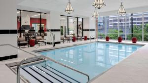 une grande piscine avec des chaises et des tables dans un bâtiment dans l'établissement Hilton Garden Inn Chicago McCormick Place, à Chicago