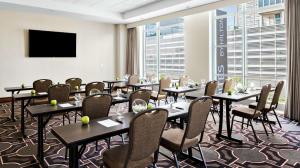 a conference room with tables and chairs and a flat screen tv at Hilton Garden Inn Chicago McCormick Place in Chicago
