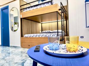 a blue table with two glasses and a bunk bed at Linea1 Amalfi Coast 500 Mt Beach in Maiori