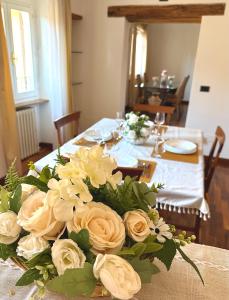 una mesa con un ramo de rosas blancas. en Royal Domus Perugia - via Mazzini, en Perugia