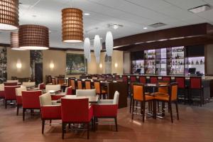 a restaurant with tables and chairs and a bar at Embassy Suites by Hilton Chicago O'Hare Rosemont in Rosemont