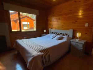 a bedroom with a bed in a wooden cabin at La Comarca Azul in El Calafate