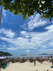 Une foule de gens sur une plage avec un ciel bleu dans l'établissement Lindo kit na quadra da praia, à Santos