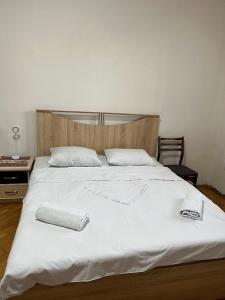ein großes weißes Bett mit zwei Handtüchern darauf in der Unterkunft Guest House SAMAN in Garni