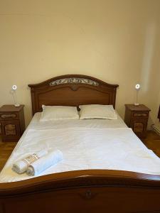 a bed with two towels on it with two night stands at Guest House SAMAN in Garni