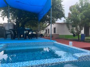 a swimming pool with a table and an umbrella at Hotel Chulamar, Piscina y Restaurante in Escuintla