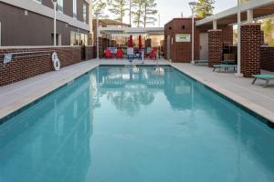 a swimming pool with blue water in a building at Home2 Suites By Hilton North Charleston University Blvd in Charleston