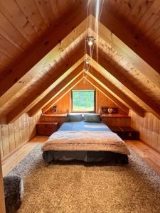 a bedroom with a bed in a wooden attic at Casa Cantone Devero-baita storica con balcone e giardino, posizione comoda e soleggiata- spazio biciclette in Alpe Devero